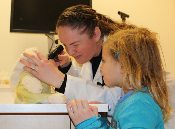 Student vet checks out Bunny's ears while her owner looks on at the open house on Dec. 1, 2012. (Andrea Connell)